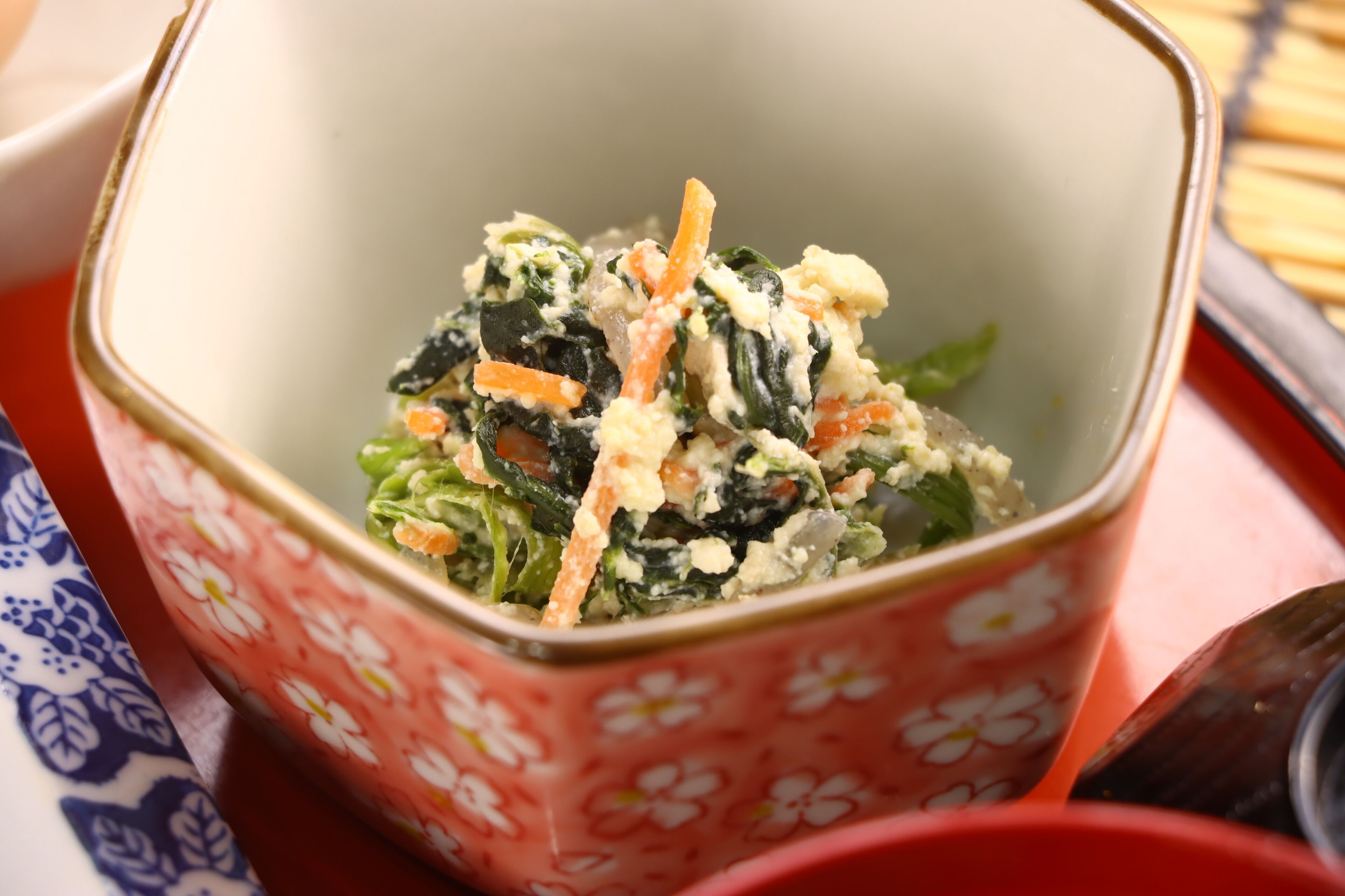 Uma saladeira com ingredientes visíveis como folhas verdes e cenouras.