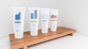 Quatre produits de soins pour la peau, disposés sur une étagère en bois.