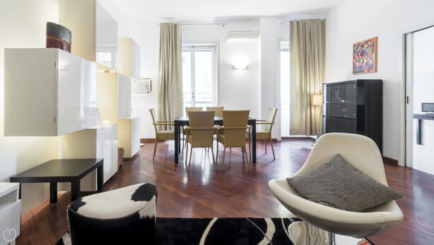 Un salon moderne comprenant un coin repas, un canapé, un téléviseur et un espace cuisine.