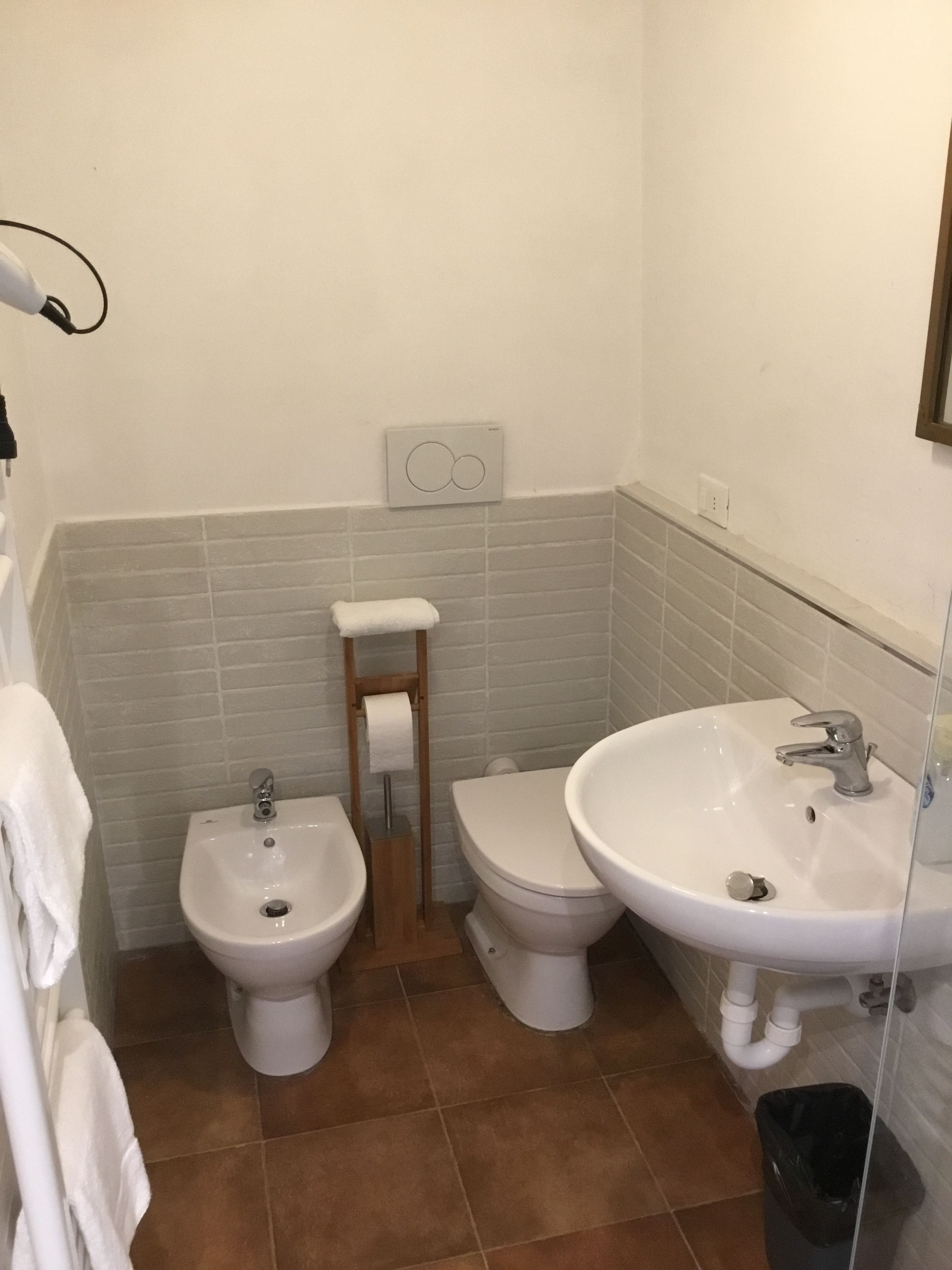 A bathroom with a bidet, toilet, and sink.