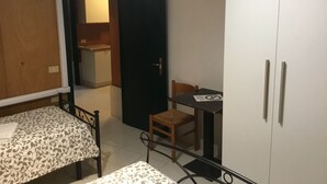Una habitación pequeña con cama, escritorio y armario.