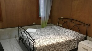 Un dormitorio con cama, mesita de noche y una silla.