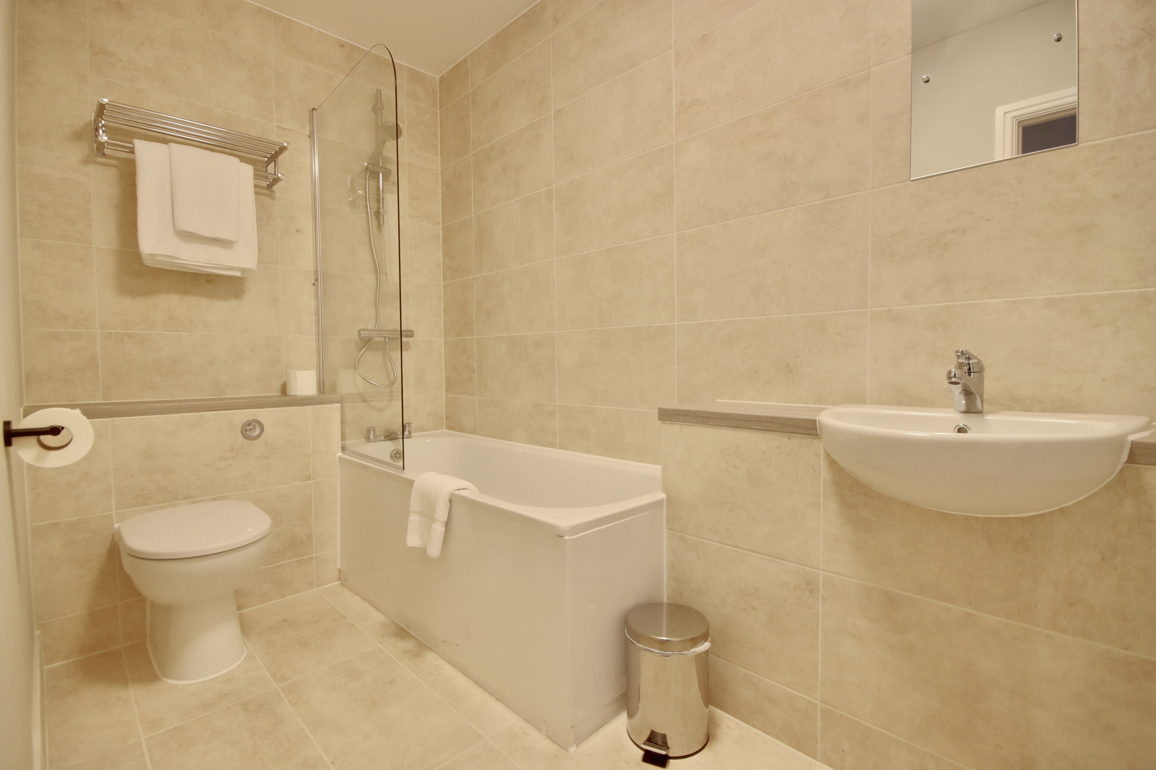 A bathroom with a toilet, bathtub, sink, and shower.
