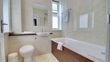 Un baño moderno con inodoro, lavamanos y bañera.