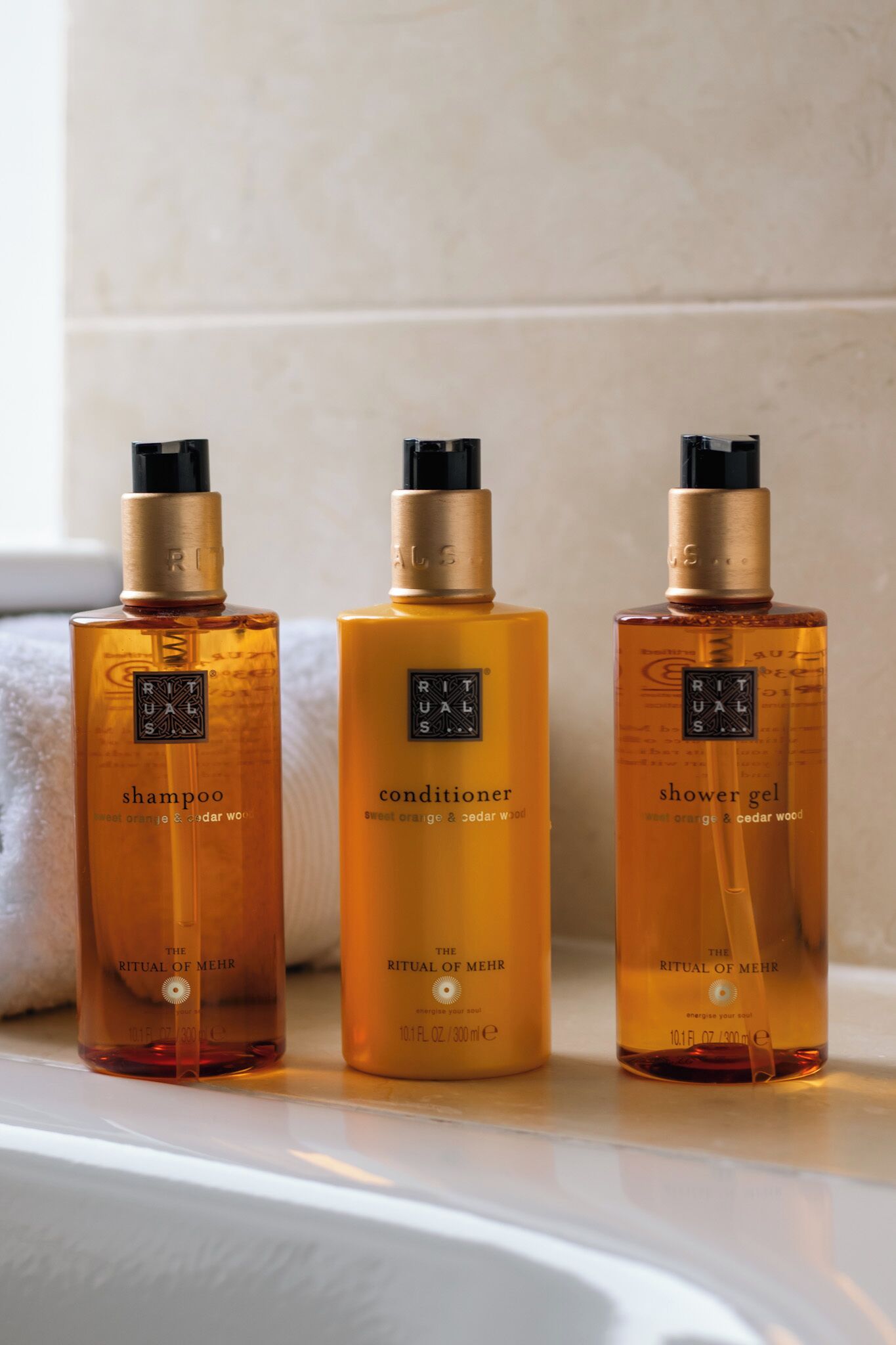 Drei Flaschen von Rituals Mehr Produkten auf einem Regal.