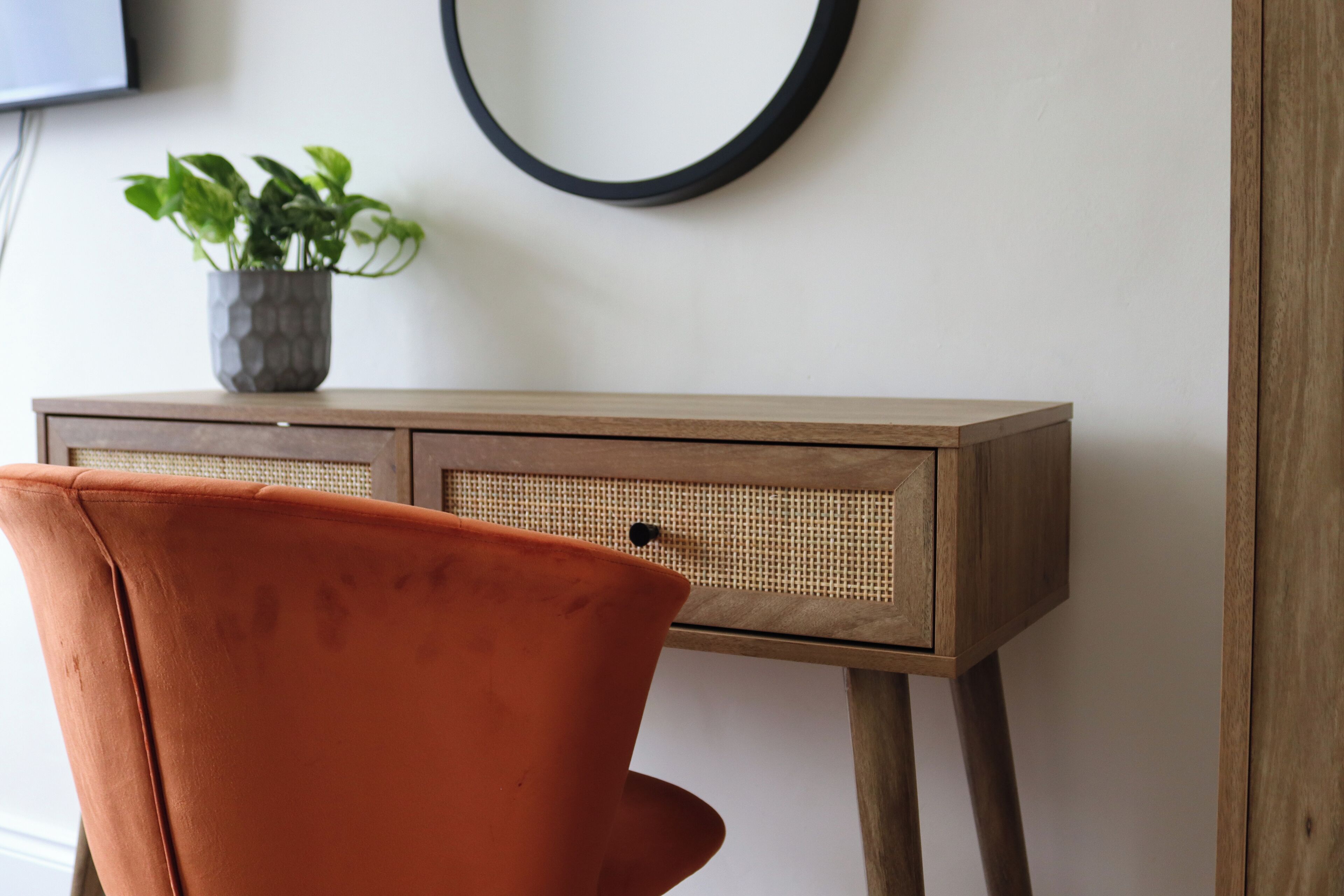 Ein Holztisch mit einem gewebten Korb und einem Blumentopf.