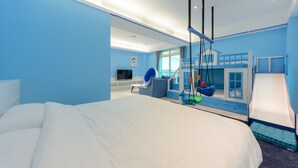 Habitació d'hotel moderna amb un llit gran, una taula de treball, una cadira, un balancí penjant i un tobogan.
