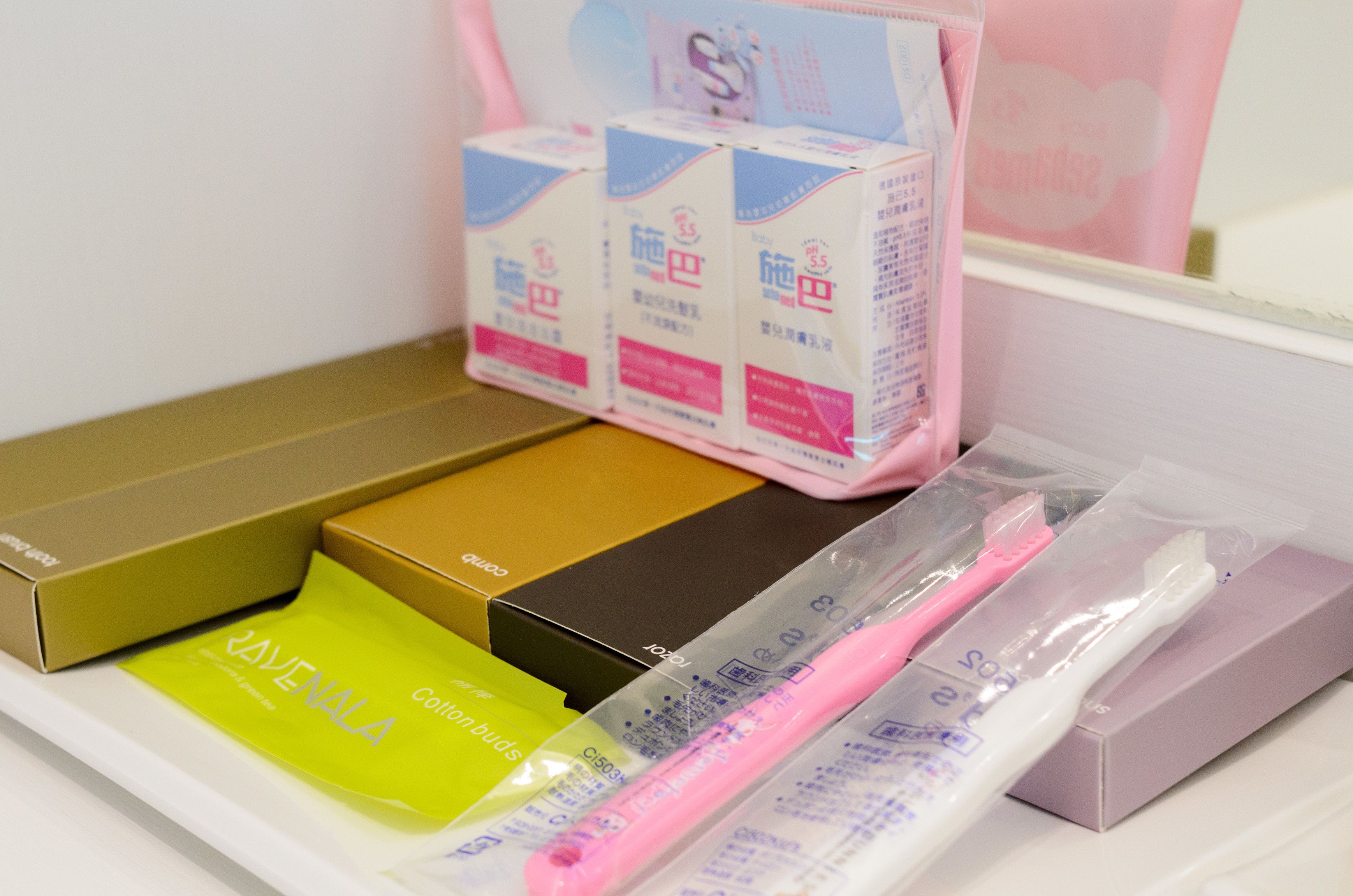 A variety of toiletries and personal care items, including toothbrushes and cotton buds, neatly arranged in a compartment.