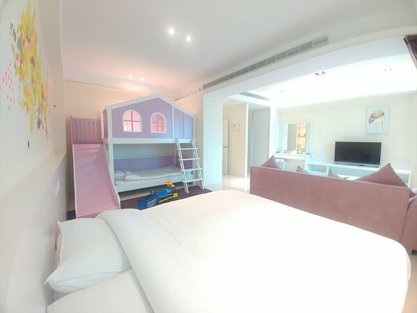 A bedroom with a bunk bed, a desk, a TV, and a pink couch. - Taiping 528 B&B (Beinan)