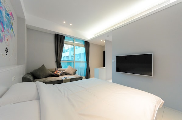A modern hotel room with a large bed, a sofa, a flat-screen TV, and a window with curtains. - Taiping 528 B&B (Beinan)