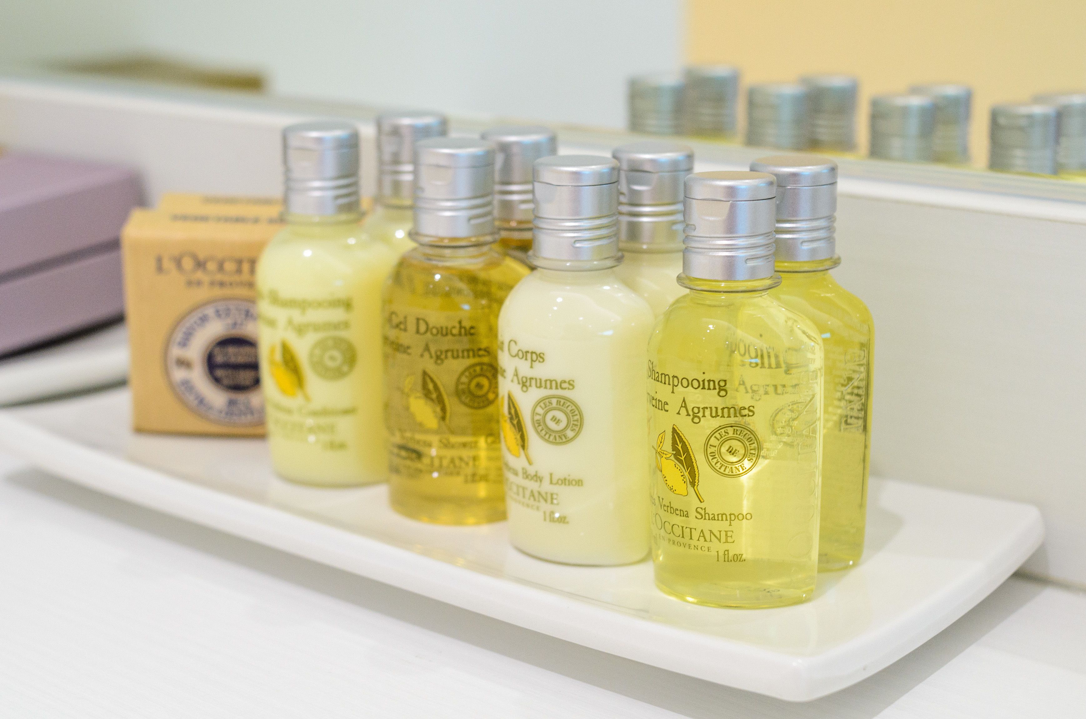 A display of L'OCCITANE body care products on a white shelf.