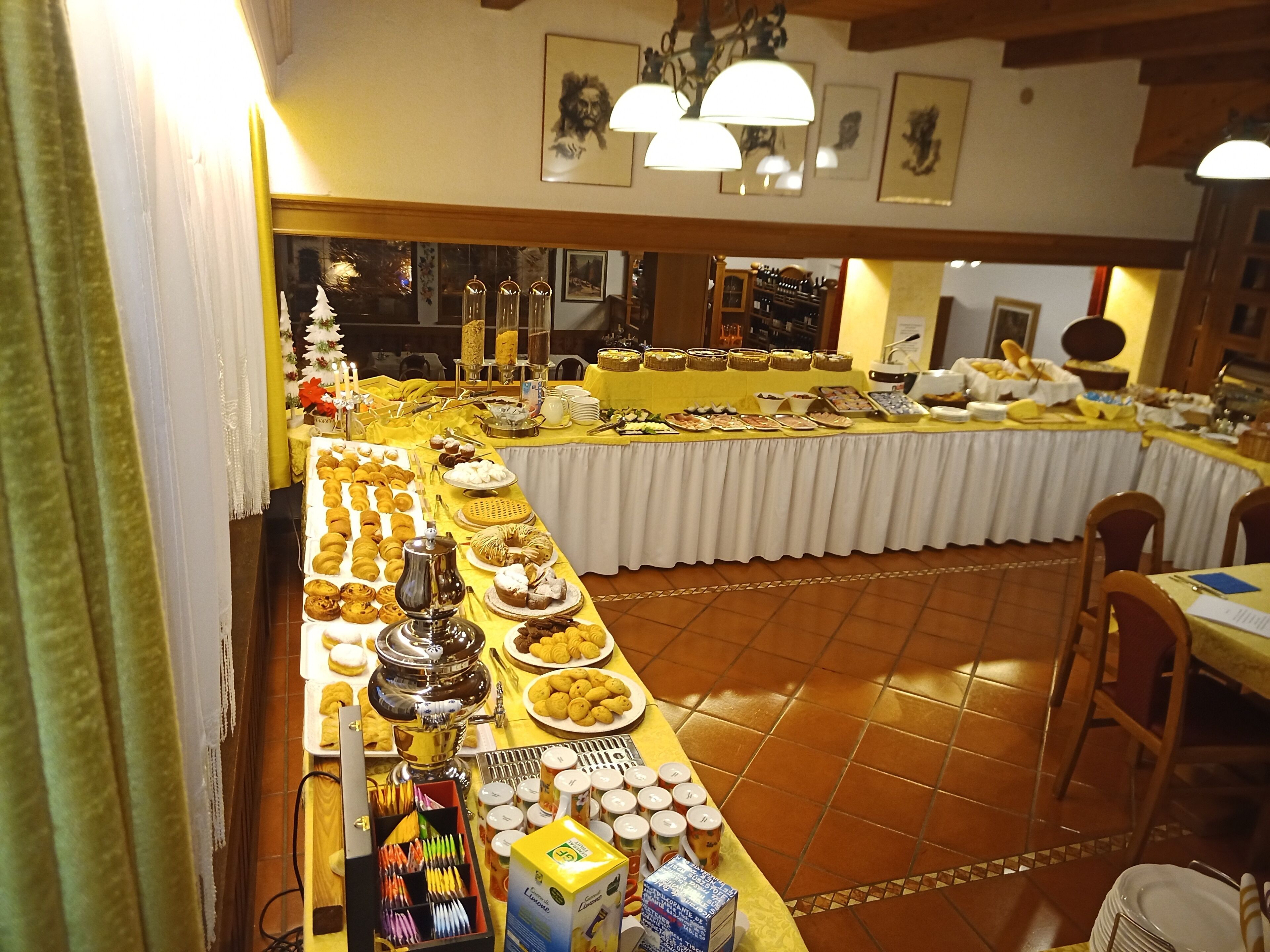 A buffet setup with various food items and beverages, a coffee machine, and a selection of utensils.