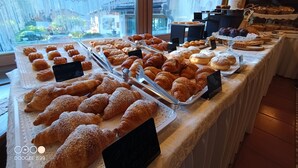 A bakery display with various pastries and a sign indicating a price of $99. - Park Hotel Arnica (Falcade)