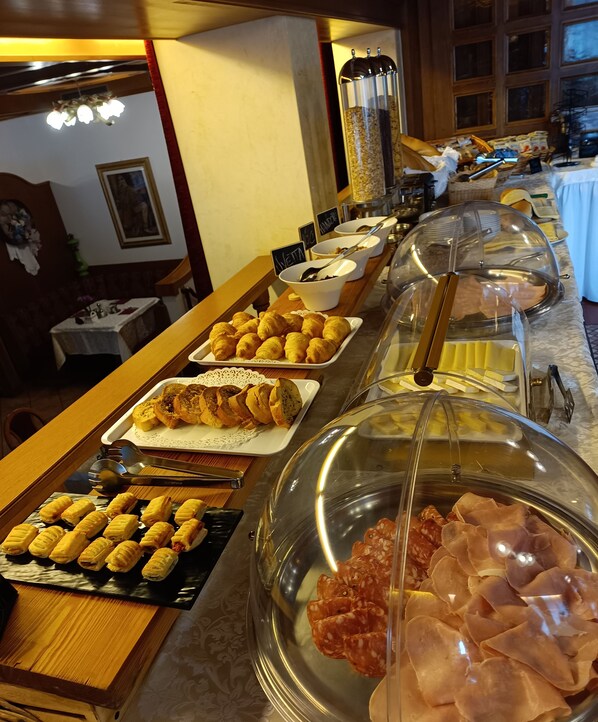 A buffet with various food items including pastries, meats, and a selection of cheeses. - Park Hotel Arnica (Falcade)