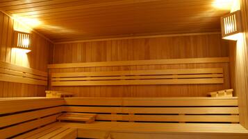 Una sauna con bancos de madera y paredes de listones.