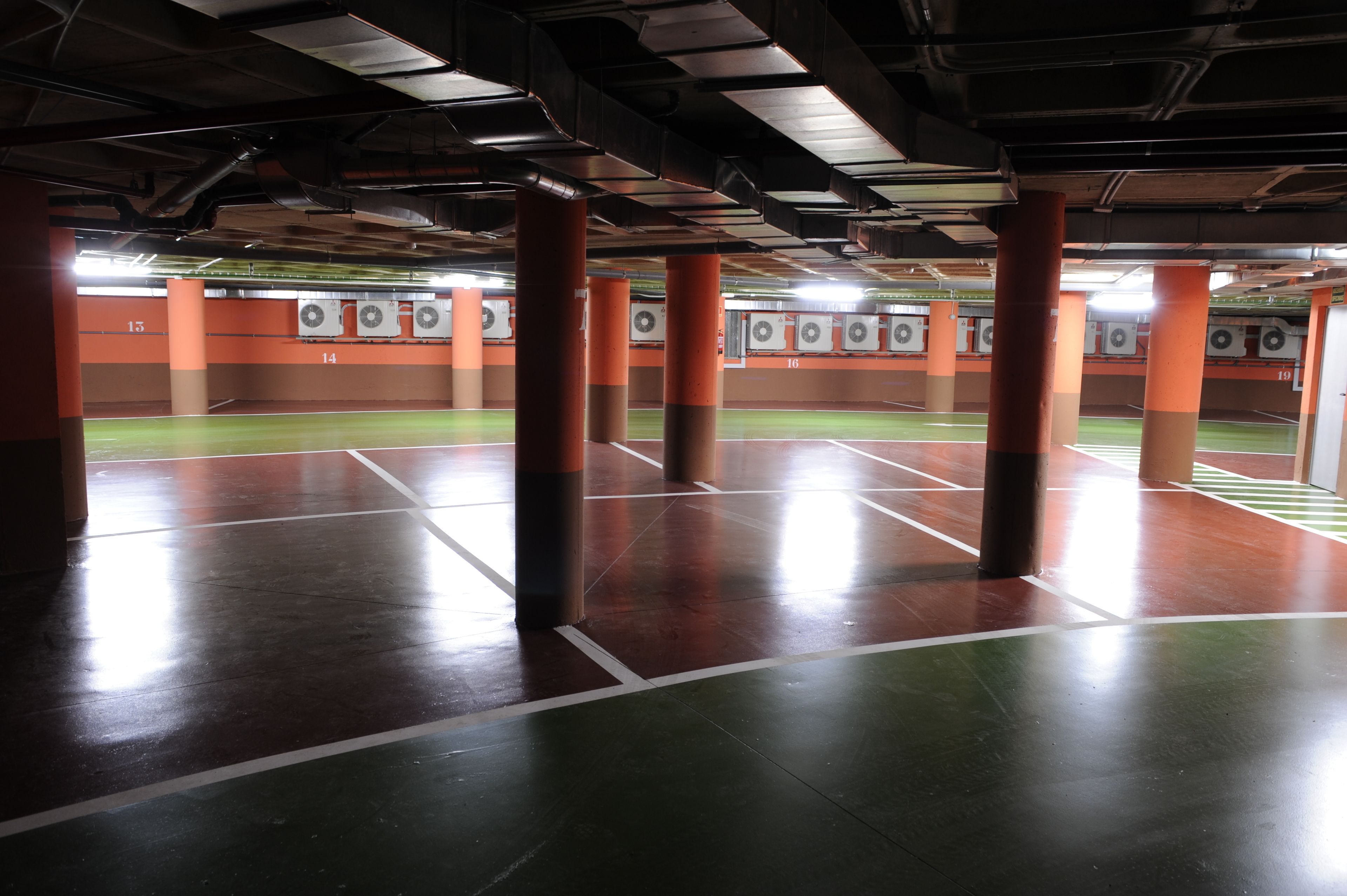 An indoor shooting range with multiple lanes, orange pillars, and targets.
