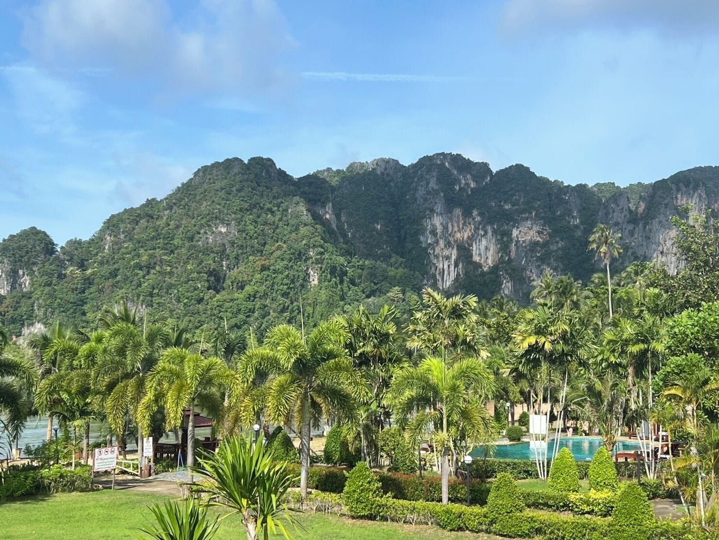 Un complexe hôtelier doté d’une piscine, d’une végétation luxuriante et offrant une vue sur les montagnes.