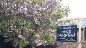 Señal para The School House Bed & Breakfast con información de contacto.