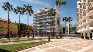Un hotel de diseño moderno, con un patio central con palmeras y suelo de baldosas.
