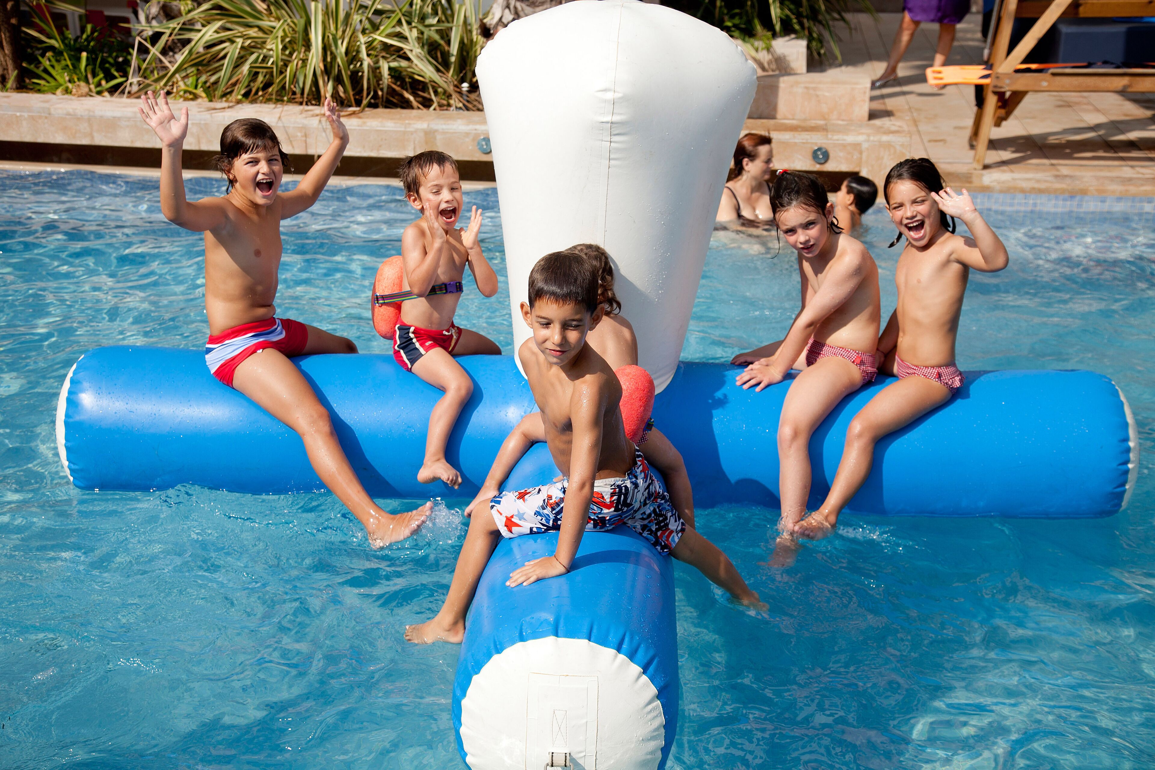 Children playing in a pool with inflatable toys.