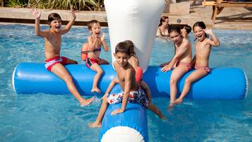 Children playing in a pool with inflatable toys.