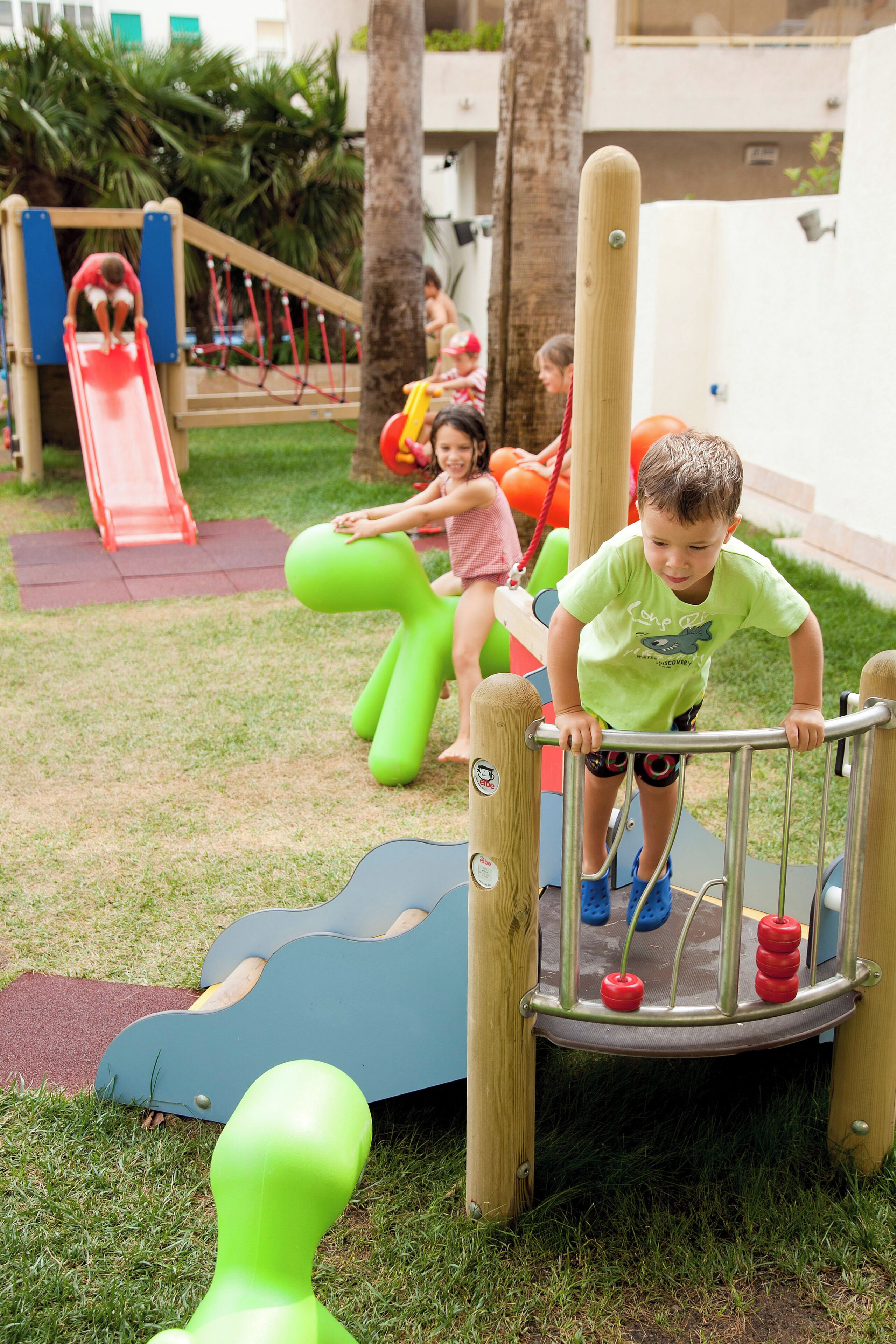 Ein Spielplatz mit Rutsche, Klettergeräten und einem Ballbecken.