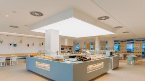Un área de desayuno moderna con una barra central, asientos e iluminación decorativa colgante.
