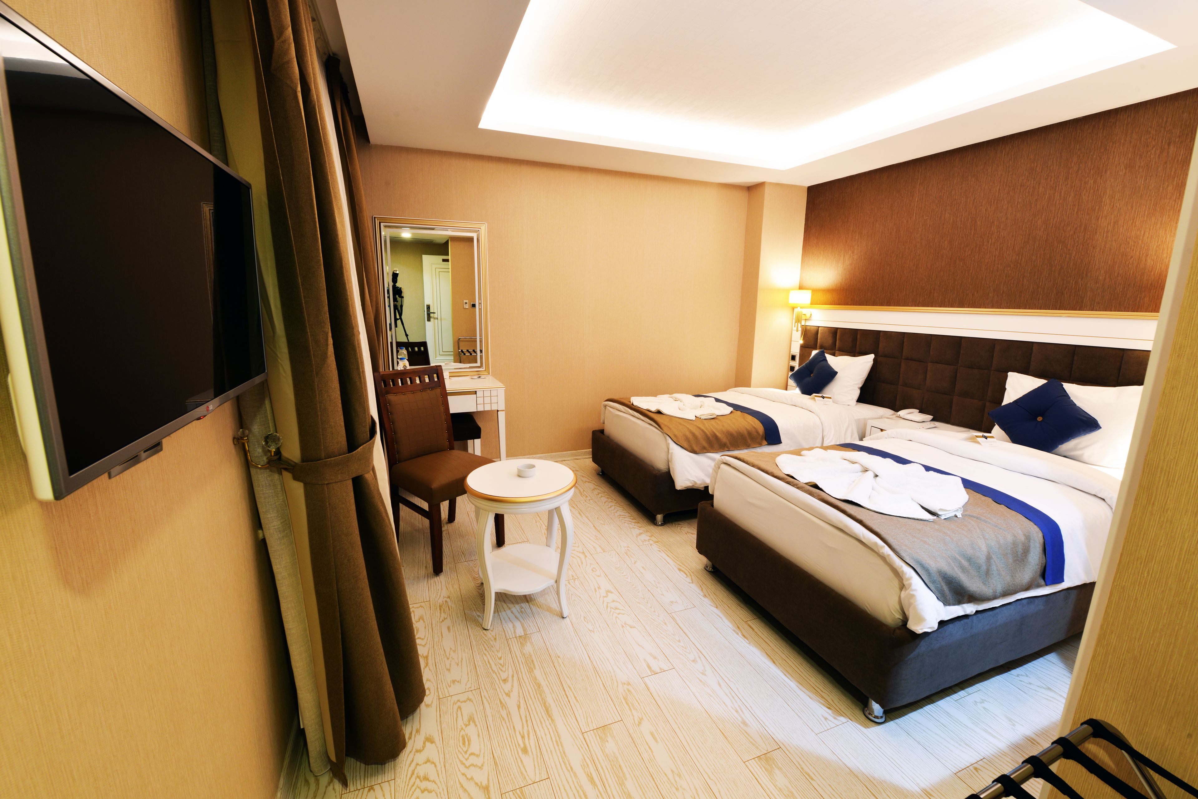 Une chambre d’hôtel avec un lit, une chaise, une petite table et un téléviseur.