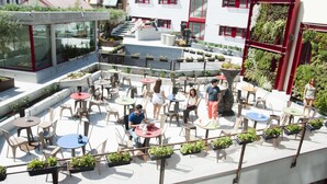 An outdoor patio area with multiple tables and chairs, surrounded by potted plants and greenery. - Funway Academic Resort - Adults Only (Madrid)