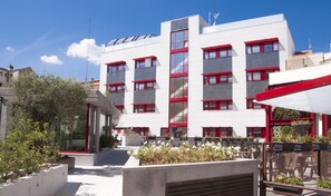 A modern building with multiple windows and a red and white color scheme. - Funway Academic Resort - Adults Only (Madrid)