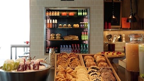 A bakery counter with various pastries and a beverage display.