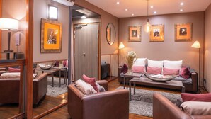 En moderne hotellobby med lædersofaer, et sofabord og indrammede kunstværker på væggene.