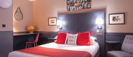 A hotel room with a large bed, a desk, a chair, and a globe.