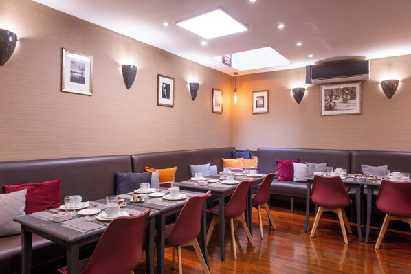 A restaurant with multiple dining tables and booths, equipped with table settings and chairs.