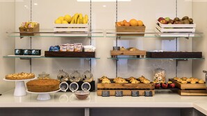 Ett bageridisplay med olika sorters bakverk och färska frukter.