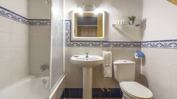 A bathroom with a bathtub, sink, and toilet.