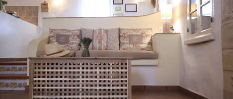A cozy room with a sofa, a wooden partition, and a window.