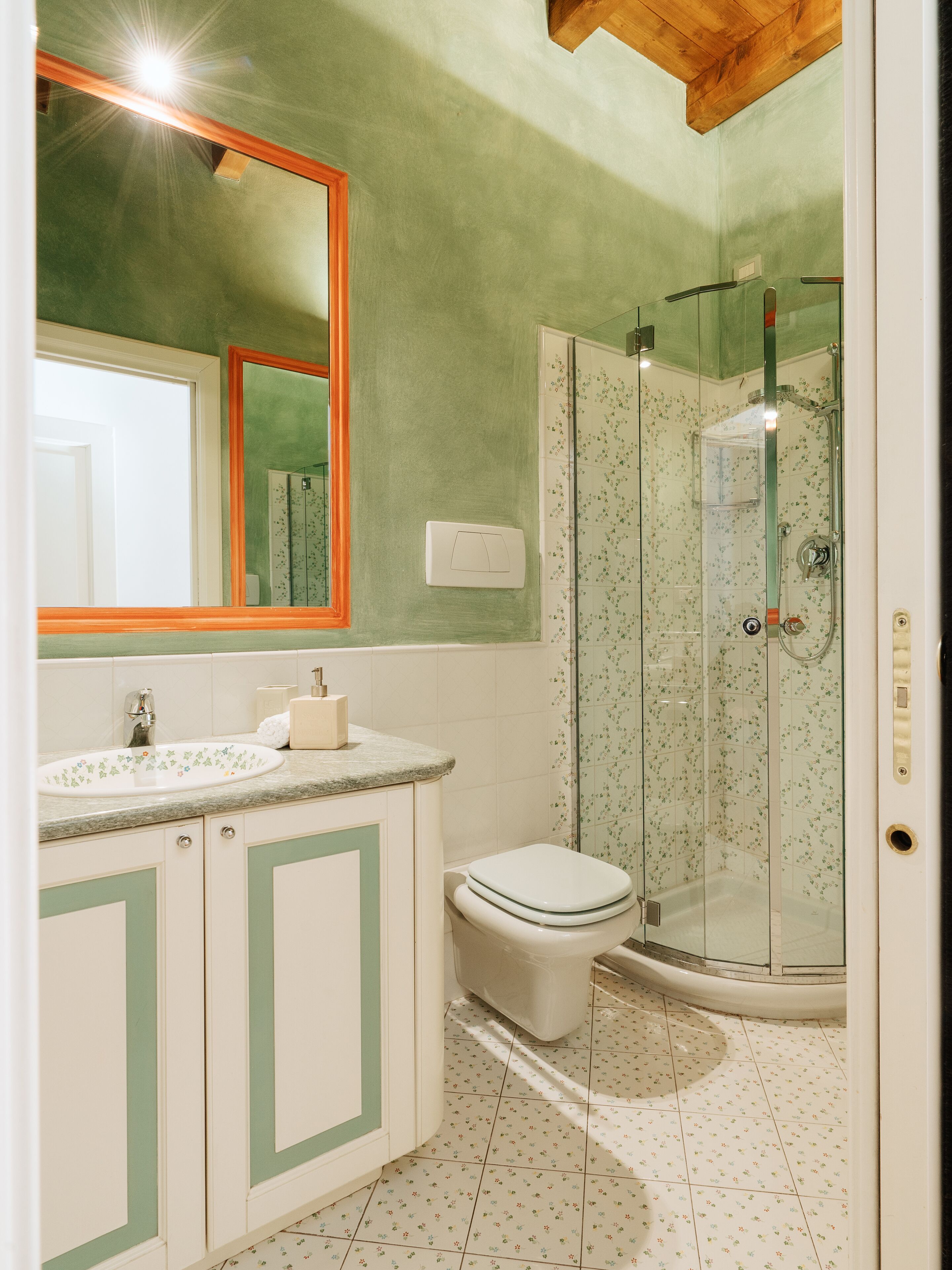 A bathroom with a sink, toilet, and glass-enclosed shower.