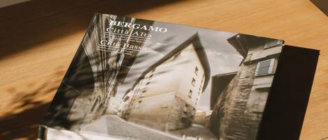A book titled 'BERGAMO Citta Alta' with a cityscape image on the cover, placed on a wooden surface.