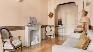 A living room with a fireplace, a sofa, and two chairs. - Quarenghi16 (Bergamo)