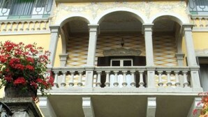 A building with a balcony featuring a patterned floor and white balustrades. - Hotel La Rondinella (Cannero Riviera)