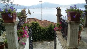 A terrace with potted plants and a view of the sea. - Hotel La Rondinella (Cannero Riviera)