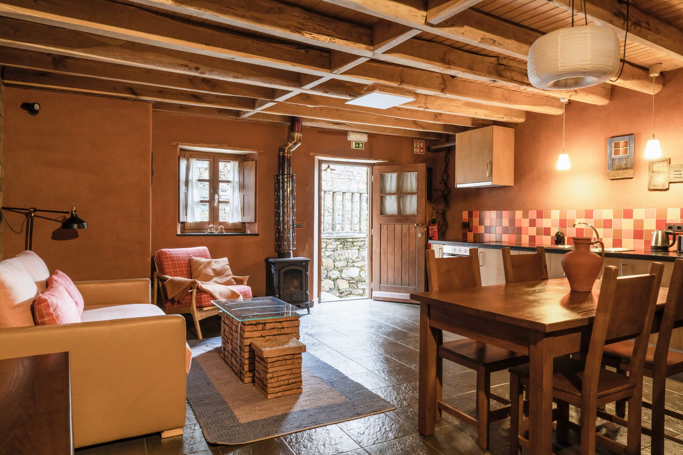 A cozy room with a sofa, a wooden table, and a fireplace.