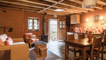 A cozy room with a sofa, a wooden table, and a fireplace.