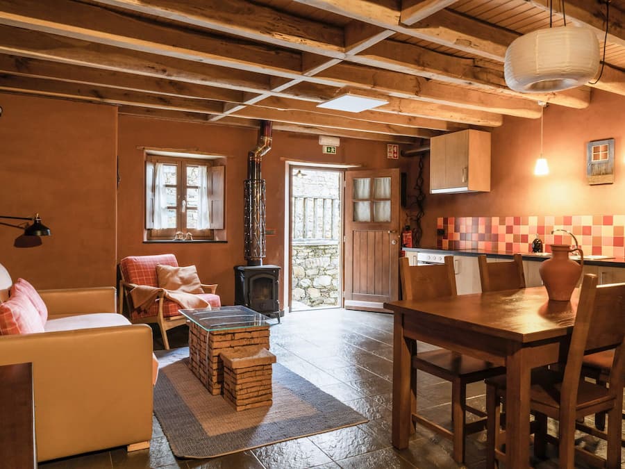 A cozy room with a sofa, a wooden table, and a fireplace.