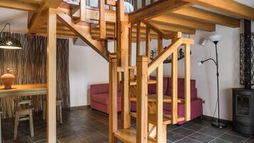 Un escalier en bois dans un salon, avec un canapé et une table.
