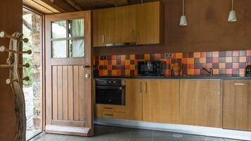 A kitchen with wooden cabinets, a microwave, and a tiled backsplash.