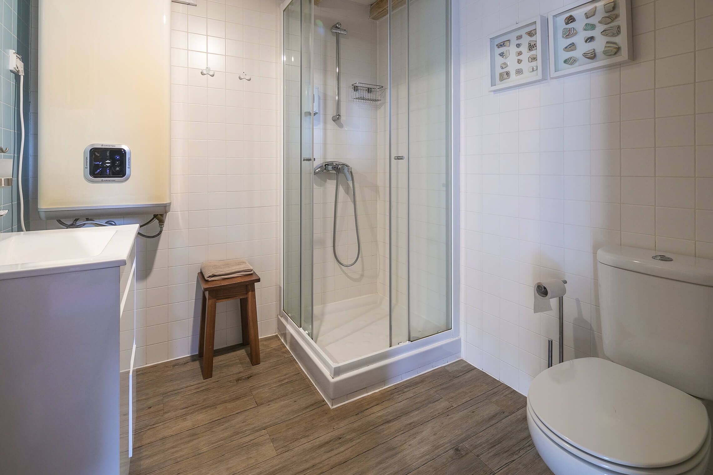 A modern bathroom with a glass-enclosed shower, a toilet, and a sink.