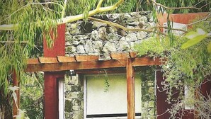 A rustic stone structure with a wooden staircase leading to a window. - Posada del Viento (Tandil)