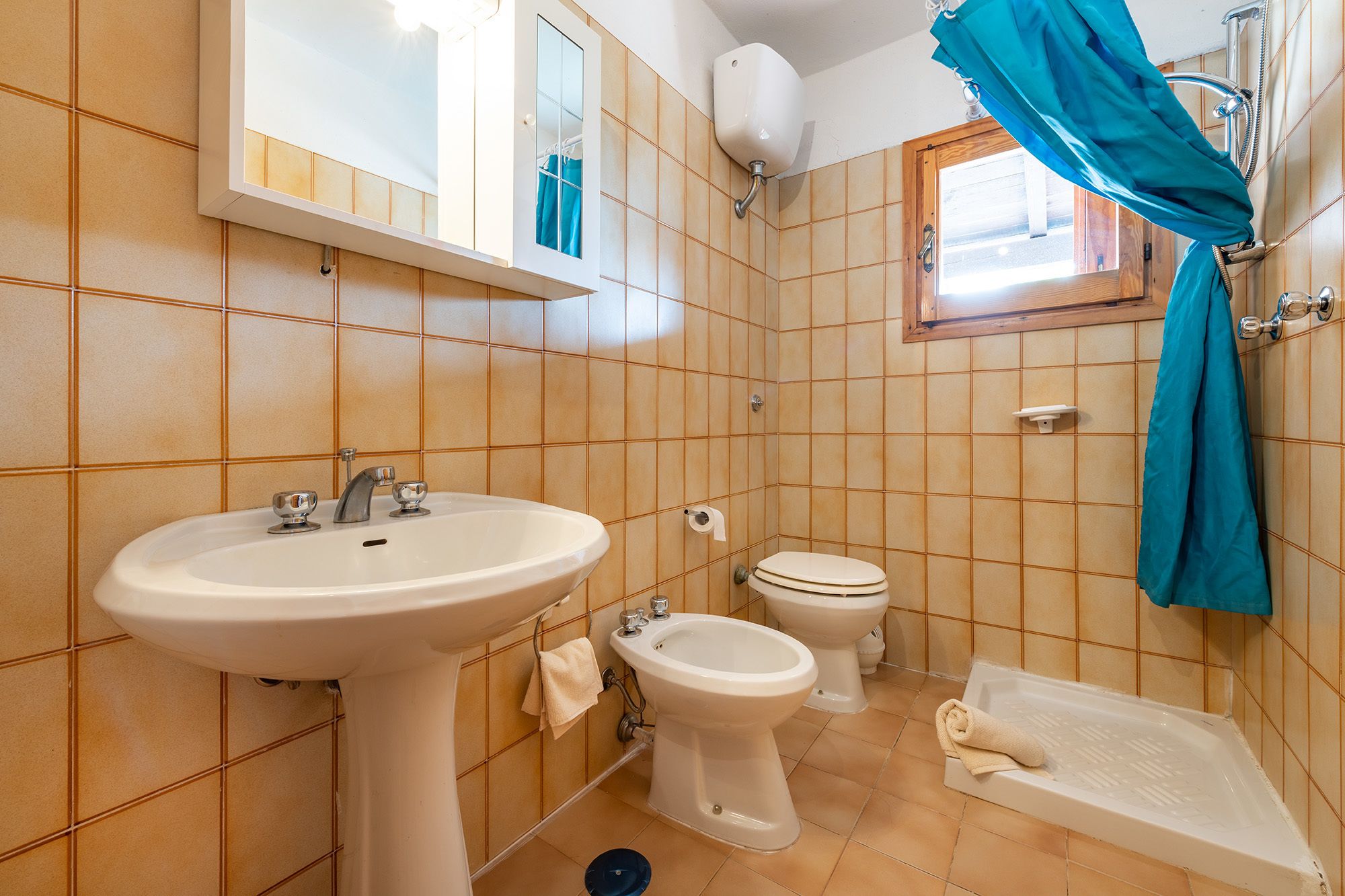 Ein Badezimmer mit Waschbecken, zwei Toiletten, einer Bidet-Funktion und einer Badewanne.